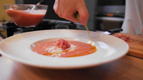 la cocinera rematando el gazpacho con aceite