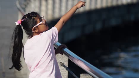 girl pointing at something from a bridge