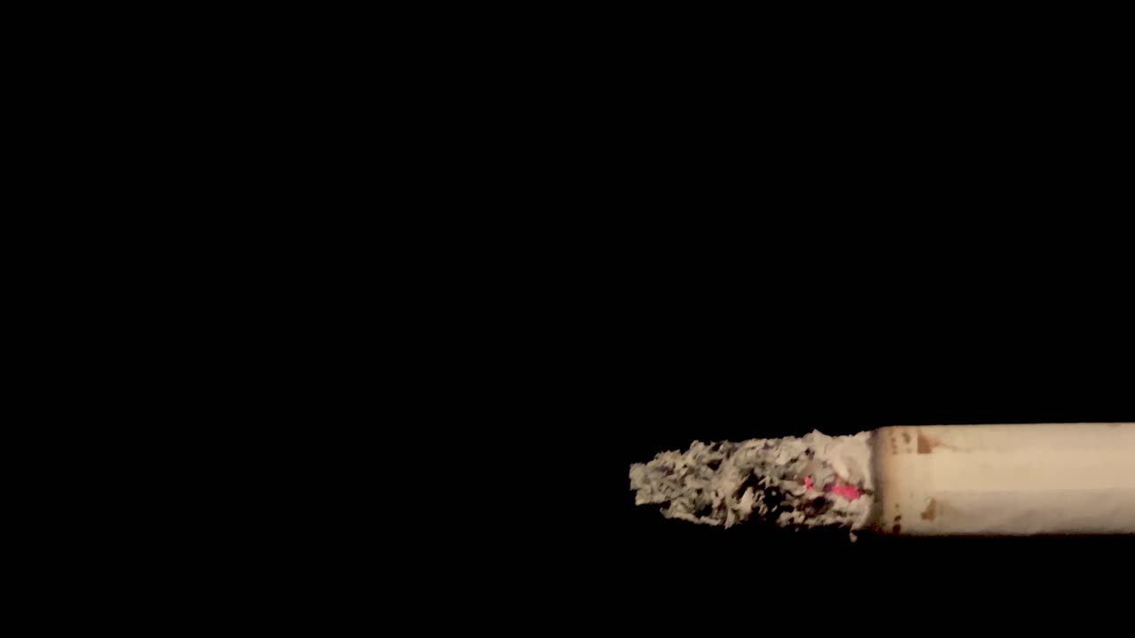 cigarrillo medio quemado de cerca con fondo negro aislado
