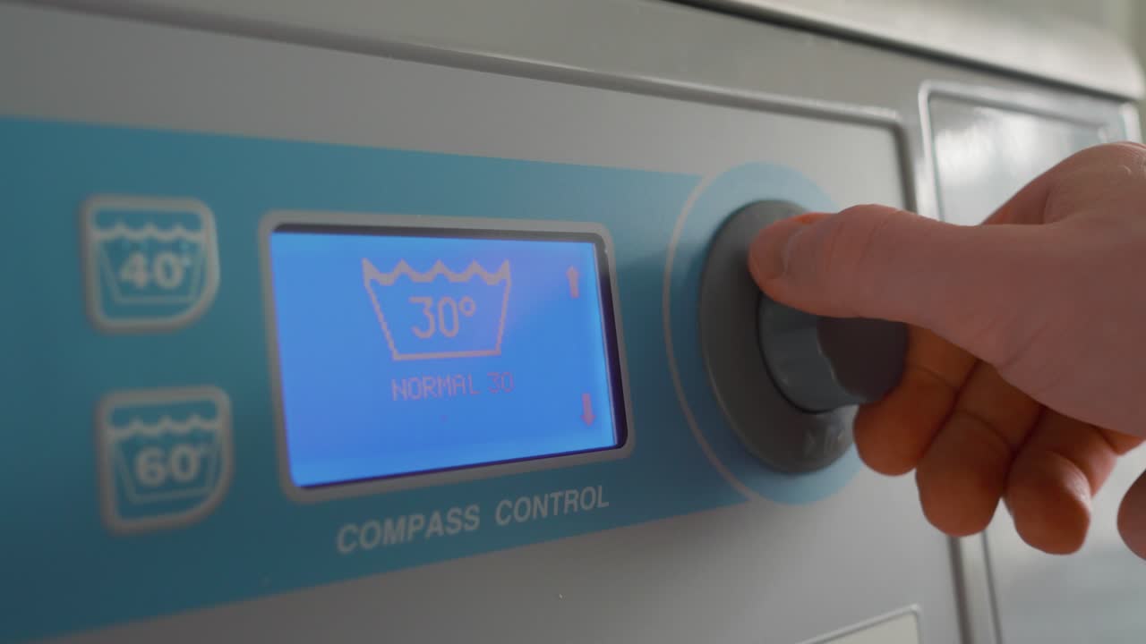 мужчина управляет стиральной машиной