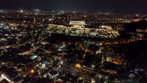 Athens-Greece-Aerial-v1-hyperlapse-drone-flyover-downtown-towards-acropolis-on-a-rocky-outcrop,-capturing-istorical-significance-and-beautiful-night-cityscape---September-2021