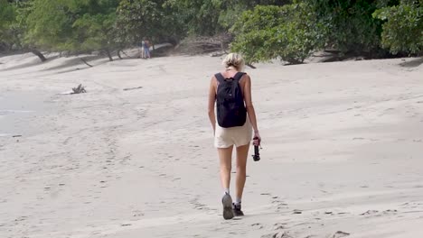 blonde girl walks on the beach of manuel antonio in costa rica