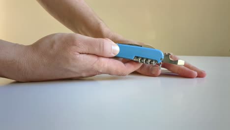 man opening folding pocket knife, close up