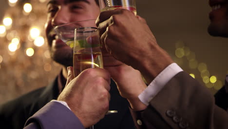 male friends make toast as they celebrate at party together