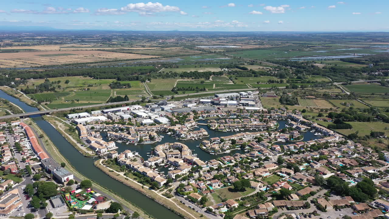 Marina de Aigues-Mortes com casas, vista aérea em dia ensolarado perto do Canal do Ródano.