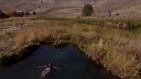 Un-Dron-Sobrevuelo-Disparó-Una-Vista-Aérea-De-Una-Mujer-En-Una-Fuente-Termal-En-Bikini-Negro