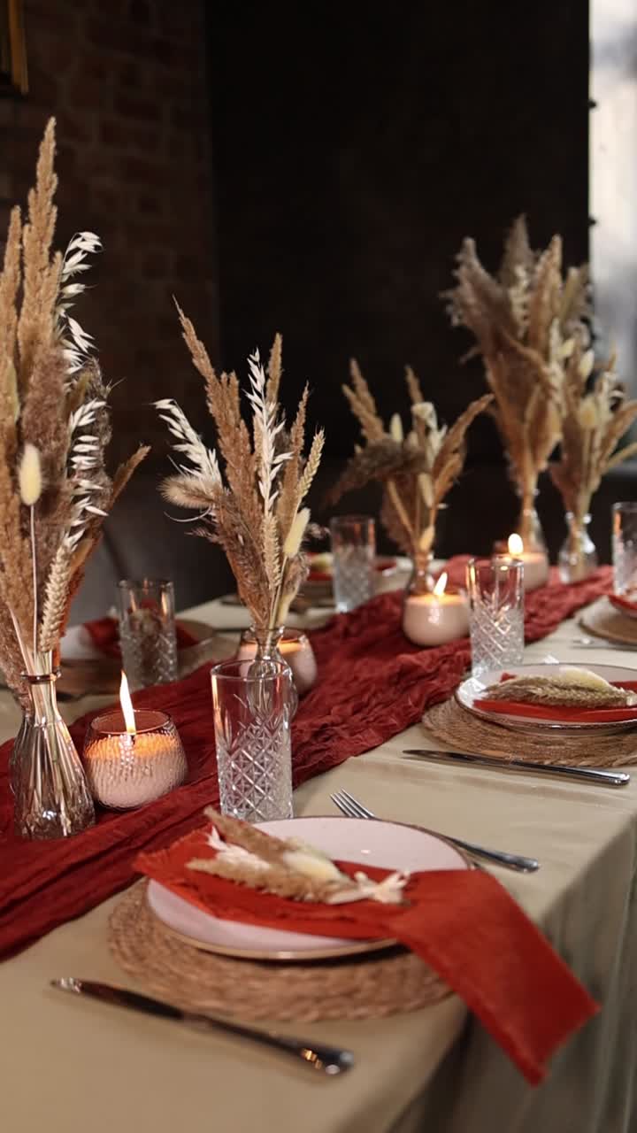 Mesa de comedor elegante decorada con hierba de las pampas y velas cálidas.