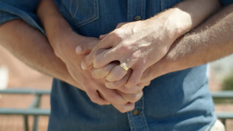 close-up shot of gays hands with engagement ring on finger