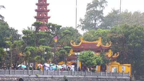 people with umbrellas at a historic temple