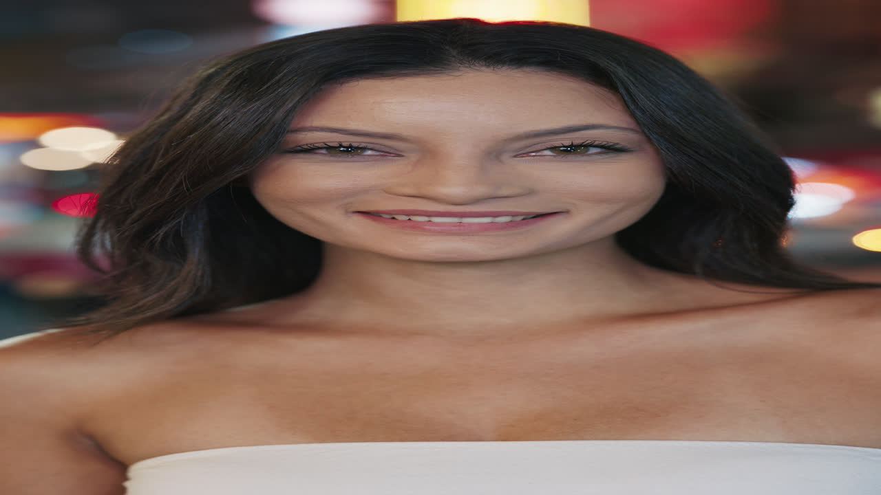 mujer sonriente por la noche en la ciudad