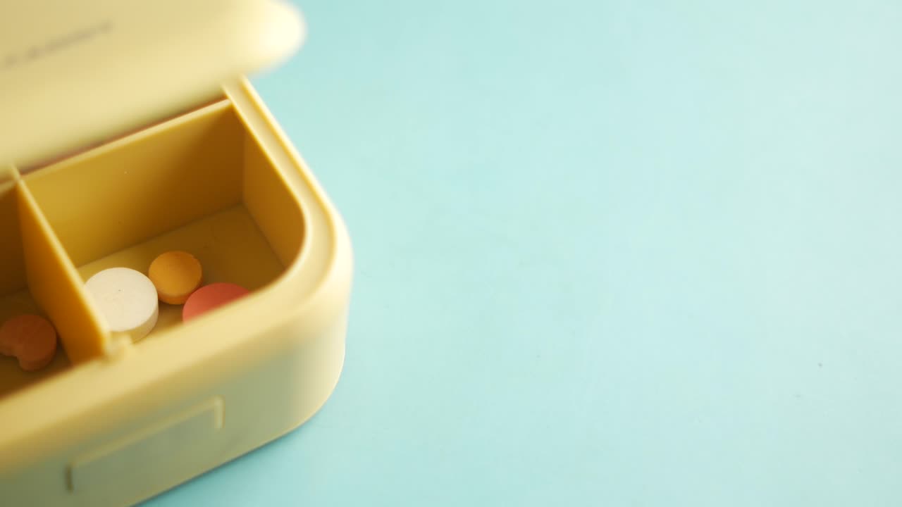 una caja de pastillas amarillas llena de pastillas de colores