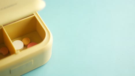 una caja de pastillas amarillas llena de pastillas de colores