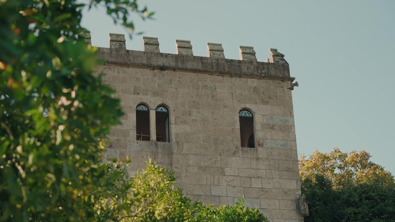 Edificio a torre in pietra in Portogallo circondato da alberi.
