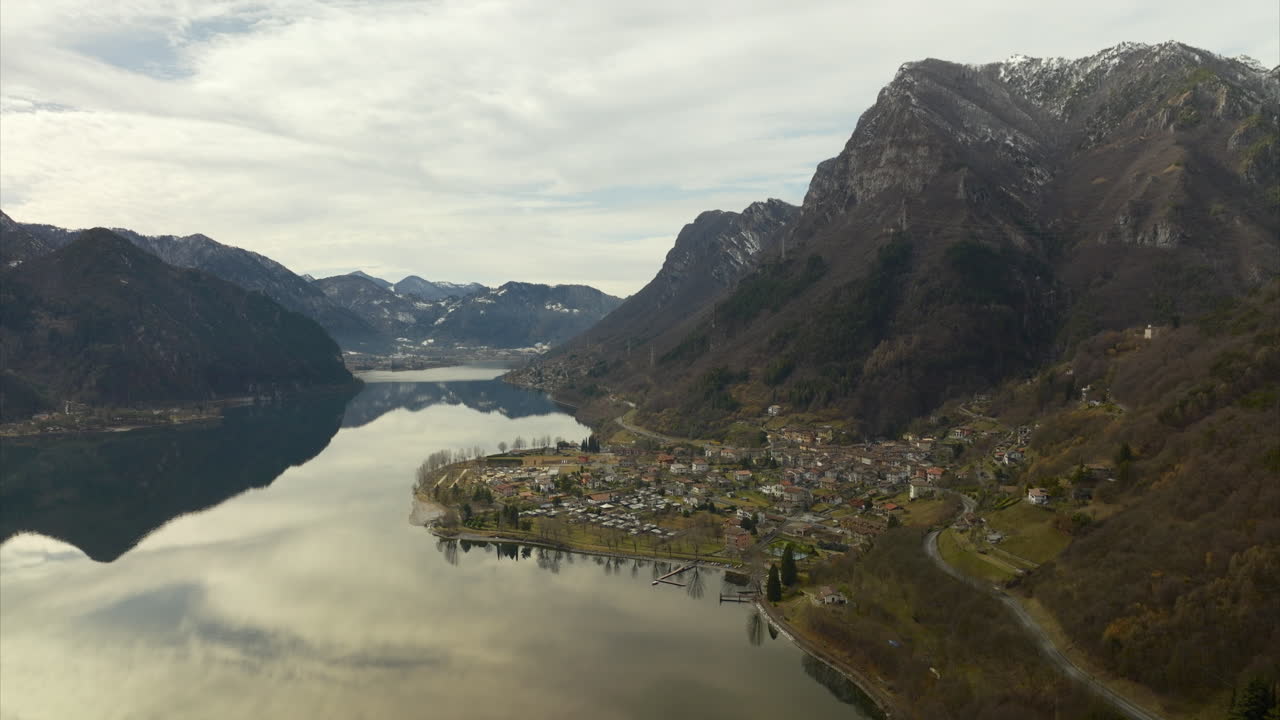 Veduta aerea della città di Anfo in Lombardia, accanto al Lago d'Idro calmo e riflettente.