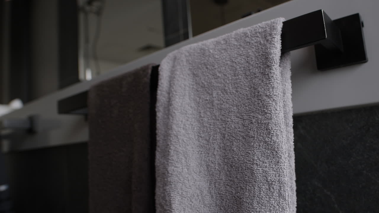 Woman taking a towel from a modern bathroom