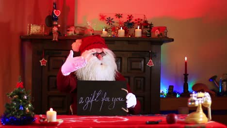 santa claus mostrando un regalo para ti nota en pizarra de tiza