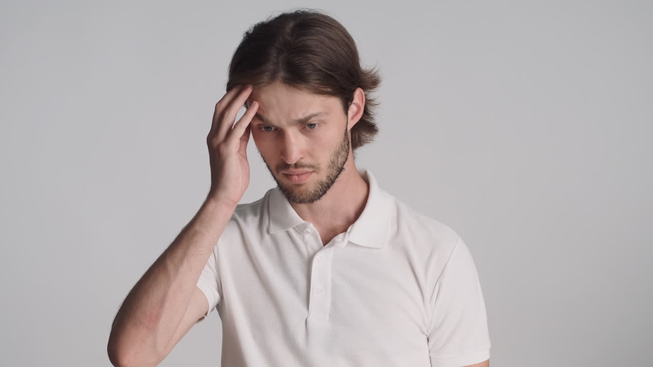 회색 배경에서 카메라 앞에 있는 백인 남자.