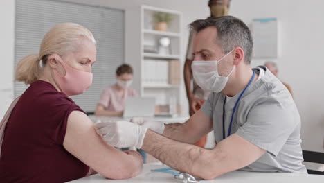 caucasian doctor vaccinating senior woman