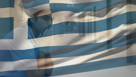 digital composition of greece flag waving against stressed caucasian male health worker at hospital