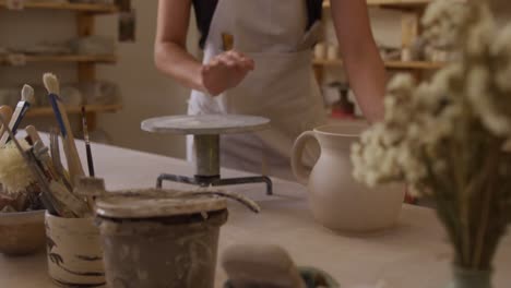 Young-female-potter-working-in-her-studio