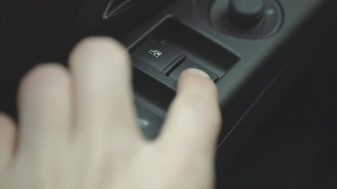 A Driver Opening And Closing A Car's Window By Pushing And Pulling The Power Window Button - Closeup Shot
