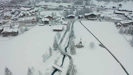 high aerial orbit of small snow covered church