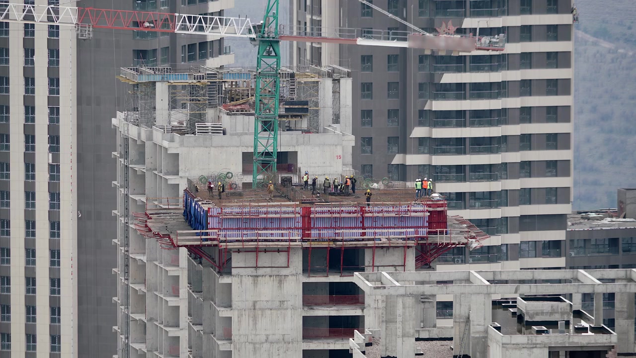 Trabajadores de la construcción trabajando en una obra de edificio de gran altura