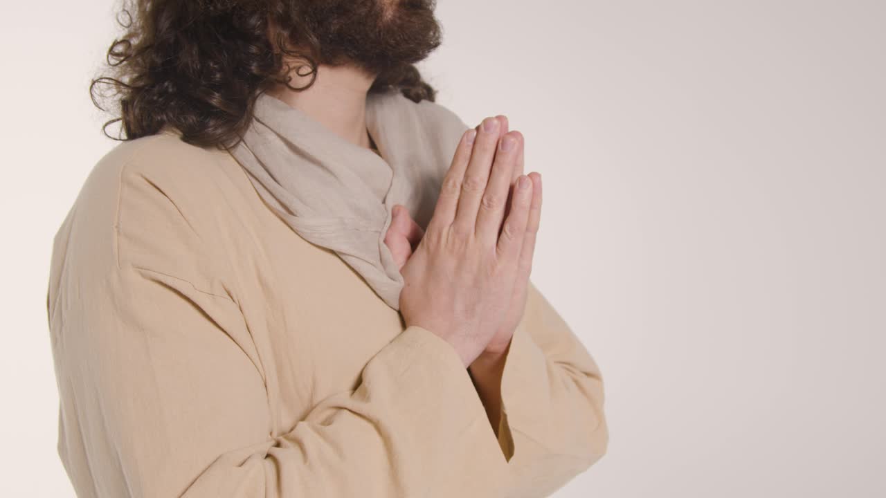 foto de cerca de un hombre vestido con túnicas con cabello largo y barba que representa la figura de jesucristo orando 2