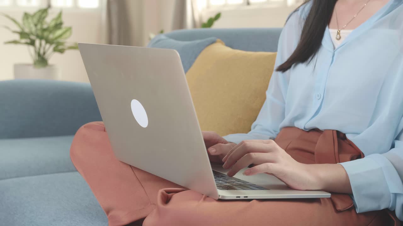 Asian Female Working On Laptop And Smiling At Living Room While Sitting On Sofa, Video In 4K