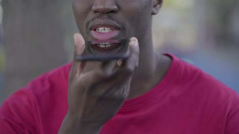 closeup of young male mouth talking on phone with speakerphone