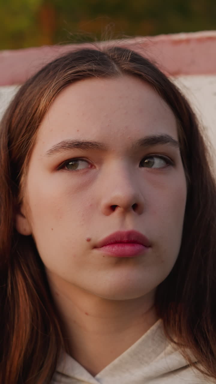 los ojos de la mujer se llenan de destellos de angustia. la mujer se preocupa por romper con el novio de pie cerca de la estructura de baloncesto rota. sensación de devastación