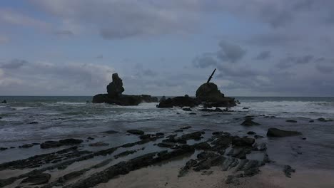 The-drone-flies-over-to-the-reef-facing-the-open-sea-where-there-is-a-Kopassus-TNI-AD-commando-knife-stuck-gallantly-on-the-beach-reef-in-Nusa-Kambangan,-Cilacap,-Central-Java