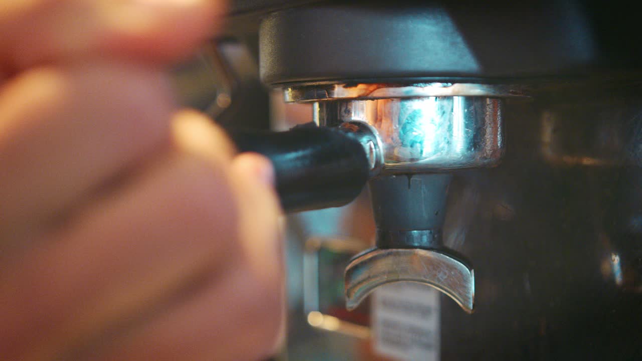 primer plano del barista masculino usando la máquina de café en una cafetería