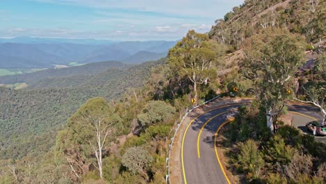 Aerial-over-the-road-that-leads-up-to-the-summit-of-Mount-Buffalo-and-looking-beyond-to-the-mountains-and-valleys