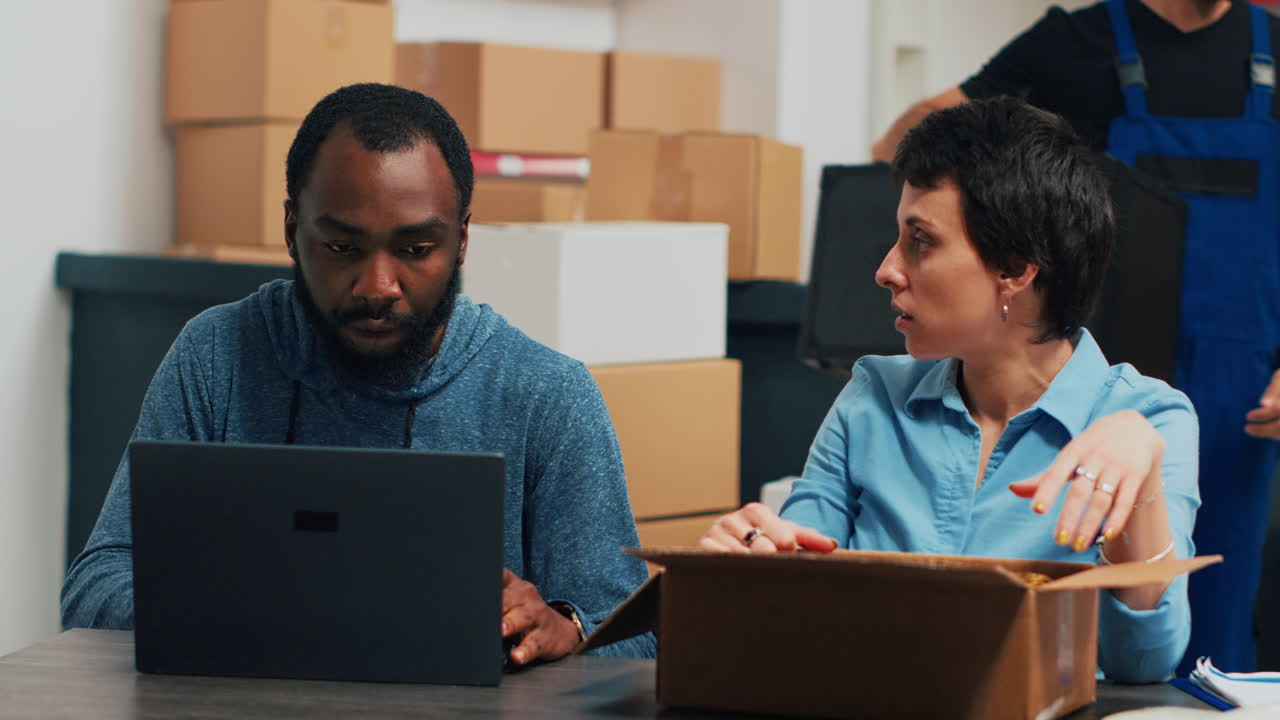 Teamwork på et lager med bærbar computer og kasser