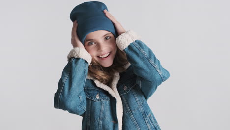 surprised teenage caucasian girl wearing denim jacket and beanie.