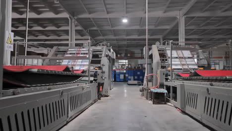 Close-up-production-assembly-line-Newspapers-being-folded-mechanically-on-a-conveyor-belt-in-a-printing-press