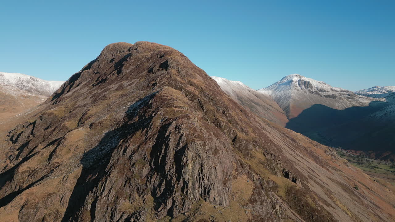 ascenso de la montaña en invierno con picos nevados en el fondo en el distrito del lago wasdale uk