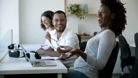joyful colleagues laughing during work