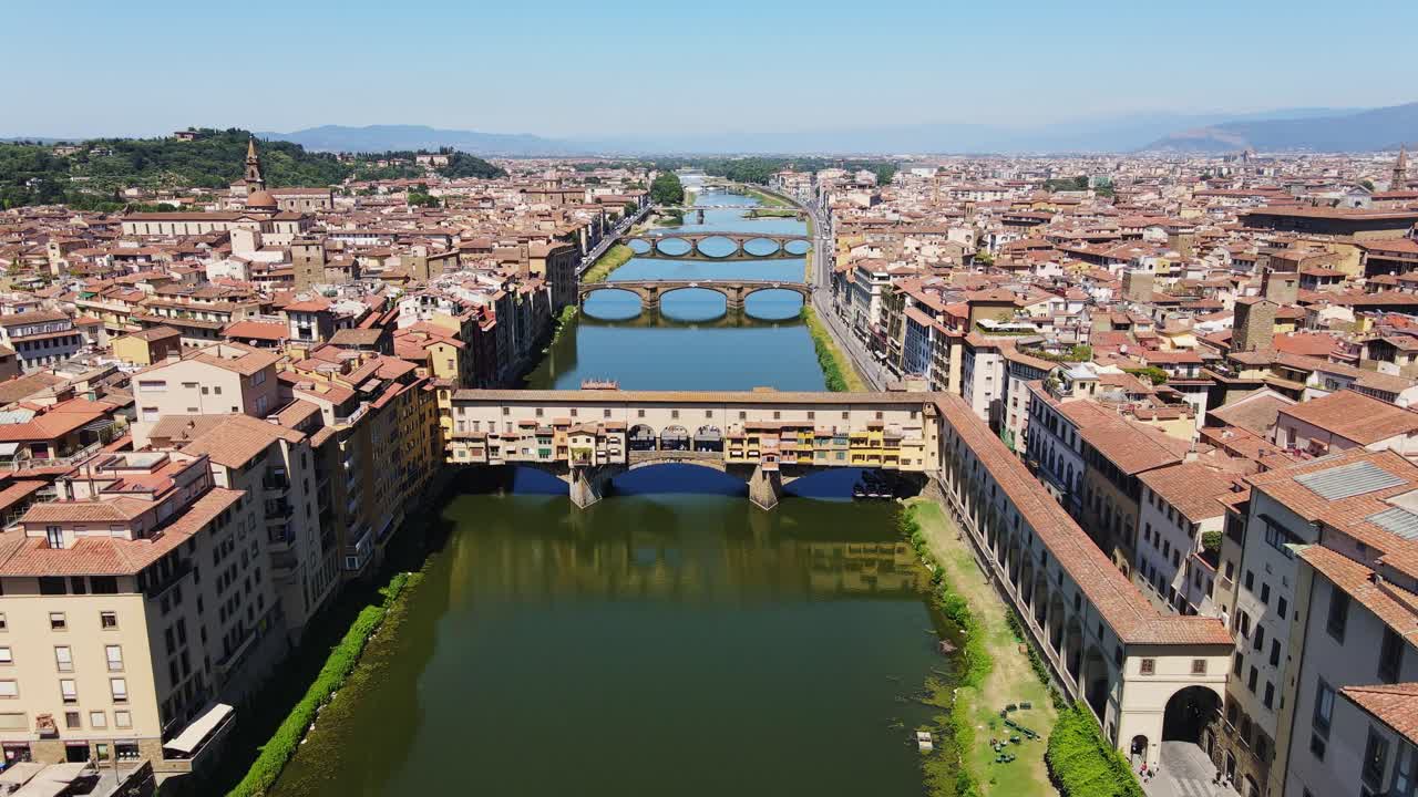 Aerial shot of iconic Florence bridge stretching over emerald green Arno River