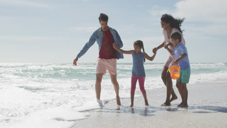 Glückliche-Hispanische-Mutter,-Vater,-Sohn-Und-Tochter-Spielen-Im-Meer-Am-Strand