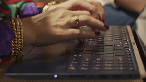 Un-Primer-Plano-De-Manos-Femeninas-Bien-Adornadas-Escribiendo-En-El-Teclado-De-Una-Computadora-Portátil