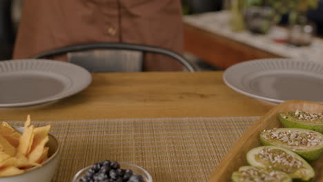 as mãos de algumas mulheres pondo a mesa para uma reunião de amigos