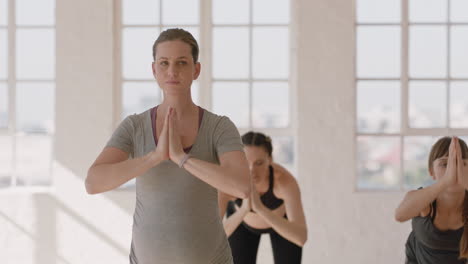 young pregnant caucasian woman in yoga class practicing standing forward bend pose enjoying healthy lifestyle group exercising in fitness studio