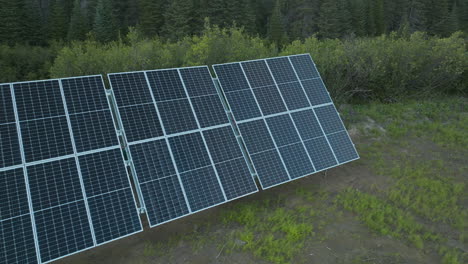 Hermosa-Foto-De-Seguimiento-Moviéndose-Sobre-Una-Fila-De-Paneles-Solares-En-Los-Bosques-De-Labrador,-Canadá