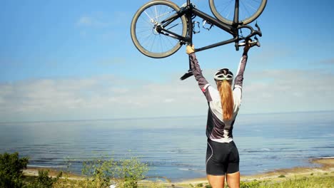 Female-cyclist-holding-bicycle-in-countryside-road-4k