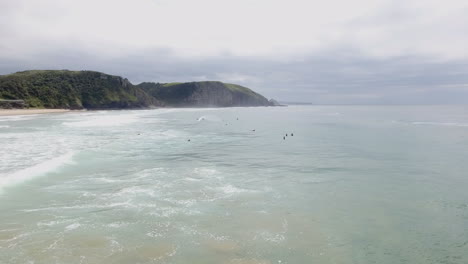 cinematic flying of surfers surfing along coast of east london south africa aerial