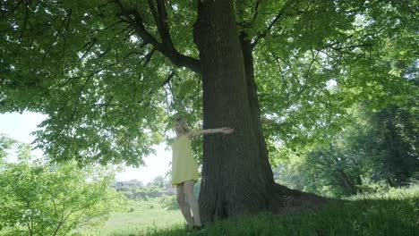 happy beautiful young girl dancing of freedom in summer park with trees in the background.