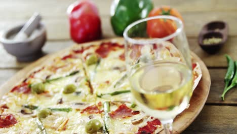 una deliciosa pizza con un vaso de vino, verduras y especias