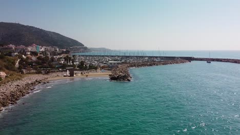 Garraf-costa,-barcelona,-with-sunlit-beaches-and-a-busy-marina,-aerial-view